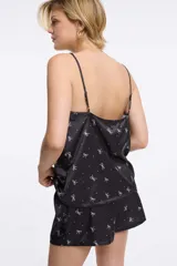 Musculosa con estampado animal print en tonos negro, blanco y verde oliva, con escote en V y detalle de encaje negro en el borde. Tirantes finos ajustables.