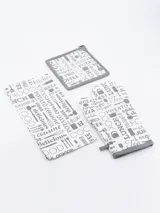 Set de cocina de tres piezas con estampado de motivos culinarios en blanco y negro, ribete gris. Incluye manopla, agarradera cuadrada y paño de cocina.