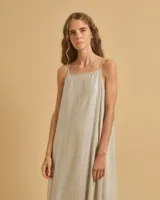 Vestido largo color beige con brillo, de tirantes finos y corte amplio.