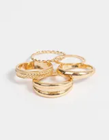 Set de cinco anillos dorados con diferentes diseños: uno liso, uno con textura trenzada, uno con textura de eslabones, uno con doble línea y uno con diseño de cuerda.