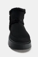 Botín negro con interior de efecto pelo, suela tipo flatforma y acabado en punta redonda.