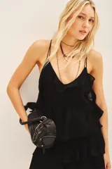 Top negro con escote en V y volados en el borde del escote. Posee tirantes finos ajustables y elástico en la cintura para un calce ceñido.