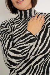 Sweater de punto con cuello alto y estampado animal print de cebra en blanco y negro.