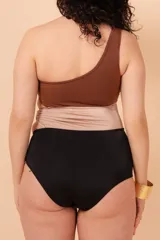 Malla entera de un solo hombro color marrón, beige y negro. Presenta aperturas laterales con aro y está confeccionada con tela que contiene fibra LYCRA® XTRA LIFE™.