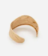 Pulsera rígida dorada con textura martillada y forma orgánica.