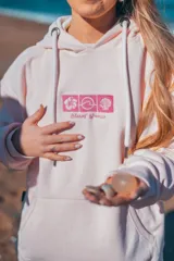 Hoodie rosa con capucha y cordones ajustables. Estampado en la espalda con motivos playeros: sol, olas, conchas y flores de hibisco.