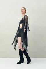 Poncho de hilo color beige con diseño calado y flecos en el ruedo.