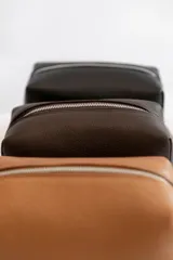 Necessaire de cuero vacuno color marrón, con cierre superior y bolsillo interno. Ideal para artículos de tocador.