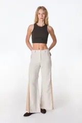 Pantalón palazzo color beige con detalles de crochet en los laterales.