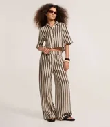 Pantalón recto de punto con rayas verticales en tonos beige y negro. Cuenta con cintura elástica y forro interior.