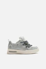 Zapatillas deportivas de skate color gris con detalles en blanco.