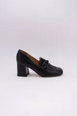 Zapato clásico de cuero azul marino, con aplique decorativo en el empeine y taco cuadrado.