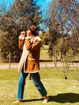 Campera gamulan color camel de cuero italiano con interior de piel sintética blanca. Tiene cuello solapa amplio, cierre con botones y bolsillos laterales.