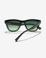 Gafas de sol Hawkers Downtown Max con montura cuadrada color verde oscuro y lentes degradadas en verde.