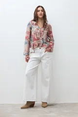 Blusa de manga larga con escote en V y volados en el frente. Presenta un estampado paisley en tonos rojo, azul y beige.