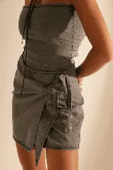 Minifalda gris de denim con corte pareo, tiro alto y lazo lateral.
