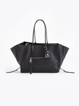 Bolso tote pequeño de cuero vacuno negro, con cierres funcionales en los laterales para mayor apertura y espacio. Incluye bolsillo cruzado interno y tag con aplique metálico.