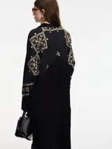 Vestido camisero negro con bordados dorados de motivos geométricos.