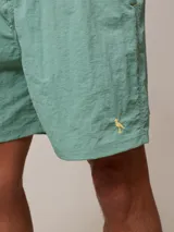 Short de baño azul marino con cintura elástica ajustable con cordón y logo de la marca bordado en rojo en la pierna izquierda.