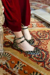 Bailarinas con estampado animal print y ribete dorado, con tacón de 2,5 cm y cuña interna de 1,5 cm.