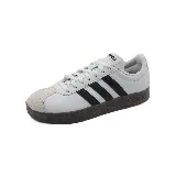 Championes Adidas VL Court Base de cuero sintético blanco con las tres tiras clásicas en negro y suela de goma marrón.