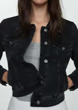 Chaqueta de jean negra con cuello clásico, cierre frontal con botones metálicos, dos bolsillos de parche en el pecho con botón, dos bolsillos laterales y mangas largas con puños abotonados.