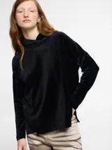 Sweater negro de tejido suave con cuello alto y diseño holgado.