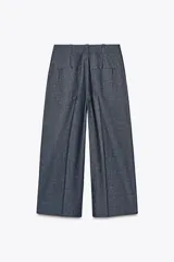 Pantalón culotte azul de lino, tiro alto, con bolsillos delanteros y traseros. Pierna ancha y corta. Cierre frontal con cremallera y botón.