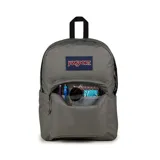 Mochila JanSport gris con logo en azul y rojo, con un compartimento principal amplio, un bolsillo frontal con cierre y tirantes acolchados.