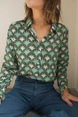 Camisa de manga larga con cuello camisero y botones frontales. Estampado con motivos geométricos en tonos verde, celeste y beige.