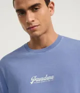 Remera celeste de algodón con cuello redondo y manga corta. Estampa centrada con la palabra "Pasadena" en letra cursiva blanca.