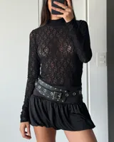 Polera de encaje negro de mangas largas.