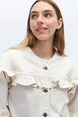 Campera de jean gris oscuro con volados en el frente y las mangas, cierre con botones metálicos.