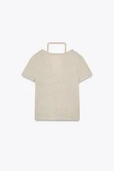 Camiseta color beige de tejido de punto, con cuello halter y escote pico. Tiene cierre frontal con botones y mangas cortas.