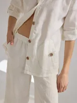 Camisa color coral de lino, corte holgado, escote redondo y mangas 3/4 ajustables con botón.