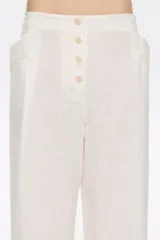 Pantalón de corte recto en mezcla de lino, largo tobillero, con cierre de botonadura frontal y bolsillos con vivo. Presenta pinzas en delantero y cintura elástica en espalda.