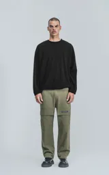 Sweater negro de corte holgado con cuello redondo y mangas largas con puños ajustados.