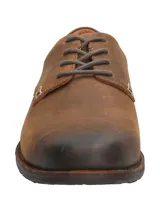 Zapato de vestir acordonado color marrón, de cuero engrasado, con suela de goma y taco bajo.