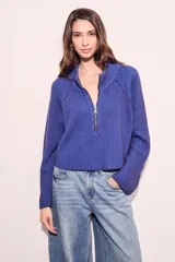 Sweater azul de tejido de punto acanalado, con cuello polo y cierre frontal parcial.
