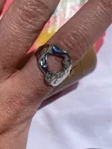 Anillo plateado de acero inoxidable con forma irregular y diseño texturizado.