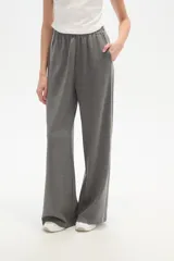 Pantalón deportivo gris oscuro con cintura elástica, bolsillos laterales y una raya blanca vertical en cada pierna.