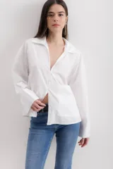 Camisa blanca de algodón con cuello clásico, mangas largas con puños abotonados y bolsillo de parche en el frente.