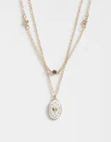 Collar corto doble dorado con dije ovalado blanco con corazón dorado y strass.