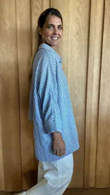 Camisa celeste de corte amplio, con cuello clásico y mangas largas.