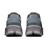 Championes de running On Cloudmonster Void, color gris con detalles en celeste y blanco. Presentan suela con tecnología CloudTec y diseño con perforaciones hexagonales.