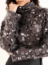 Buzo de punto gris con cuello alto y lentejuelas plateadas.