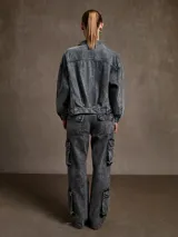 Campera de jean gris con efecto lavado, corte recto, cuello clásico, cierre frontal con botones metálicos, bolsillos con solapa en el pecho y bolsillos laterales.