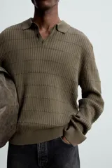 Polo color verde oliva de corte regular, tejido de punto con mezcla de algodón y cashmere. Tiene cuello solapa con cierre frontal de botonadura, manga larga y acabados en rib.