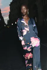 Camisa azul con estampado de flores rosas, cuello solapa y manga corta.