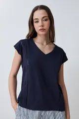 Remera color durazno con escote en V y detalle de vainillas en los laterales. De manga corta y corte recto.